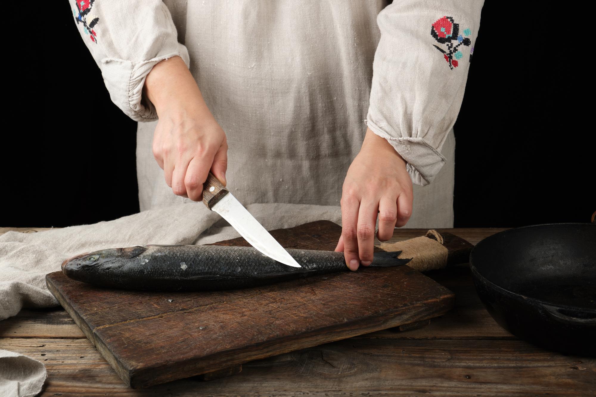Small class learning knife skills in rustic kitchen